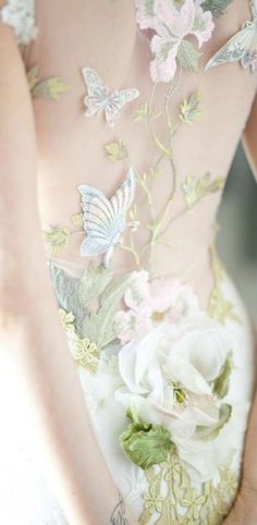 a white wedding dress with vines, flowers, and butterflies