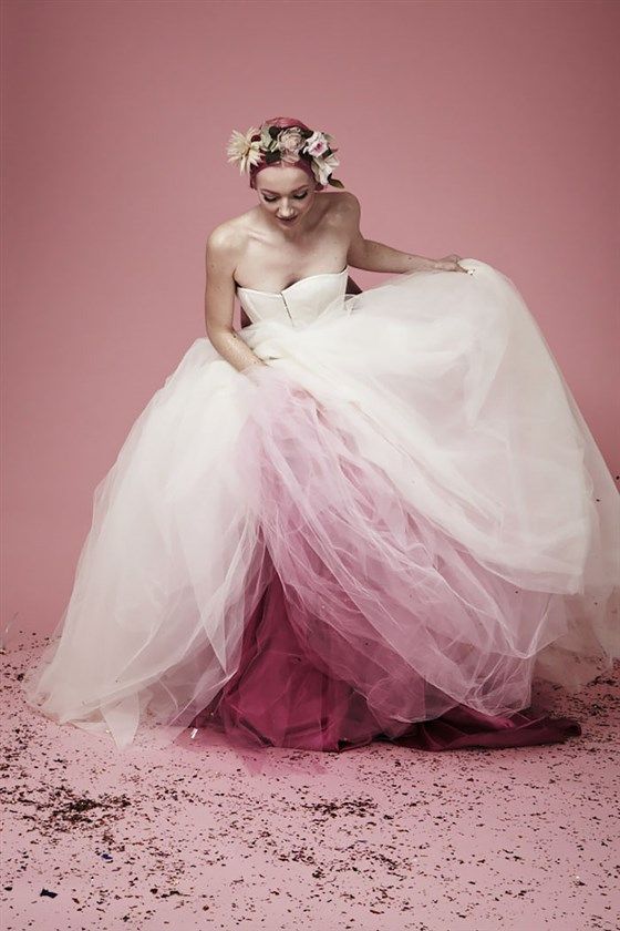 a woman in a white wedding dress with pink underneath surrounded by glitter