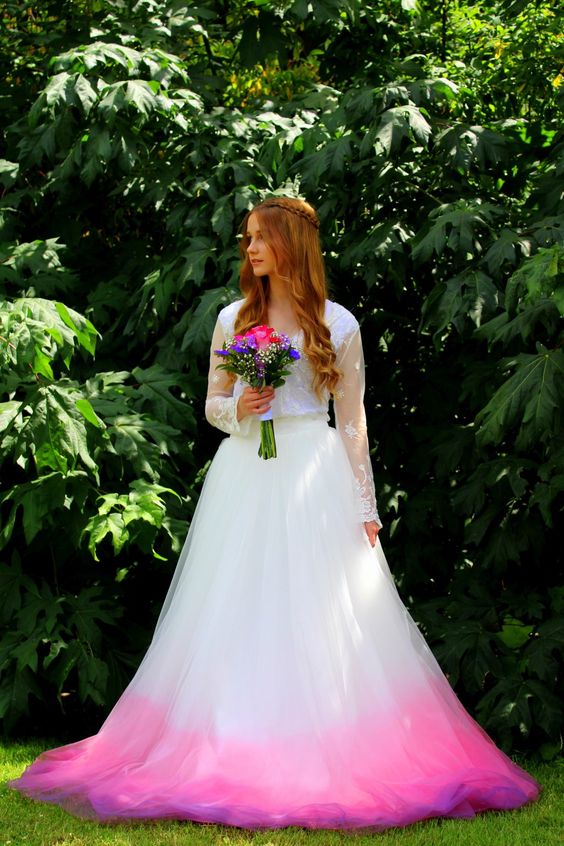 a woman in a white wedding dress with a pink skirt