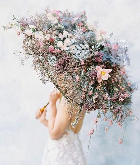 a woman in a wedding dress with a flower coverd parasol